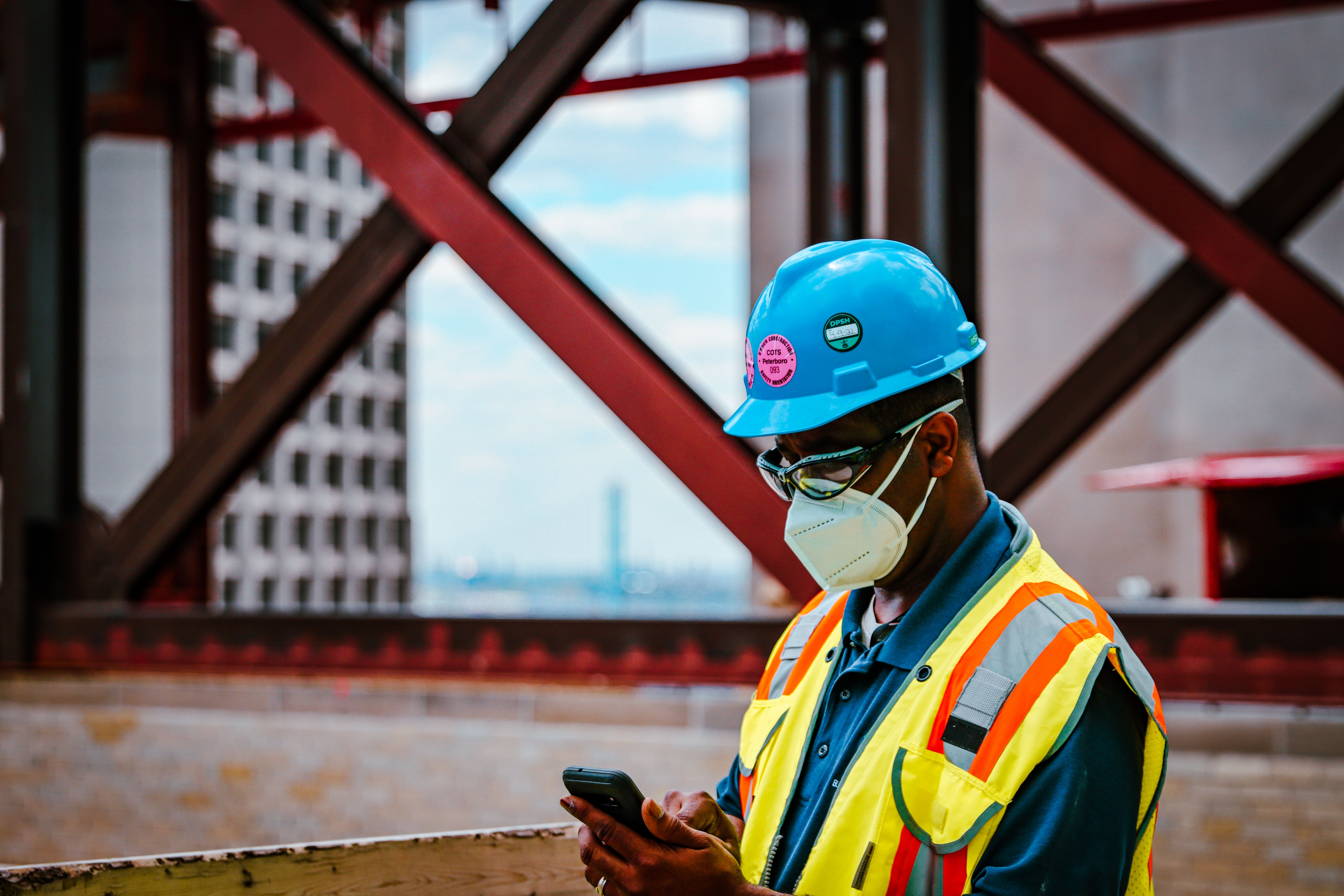 SJE engineer reviewing plans beside active construction site